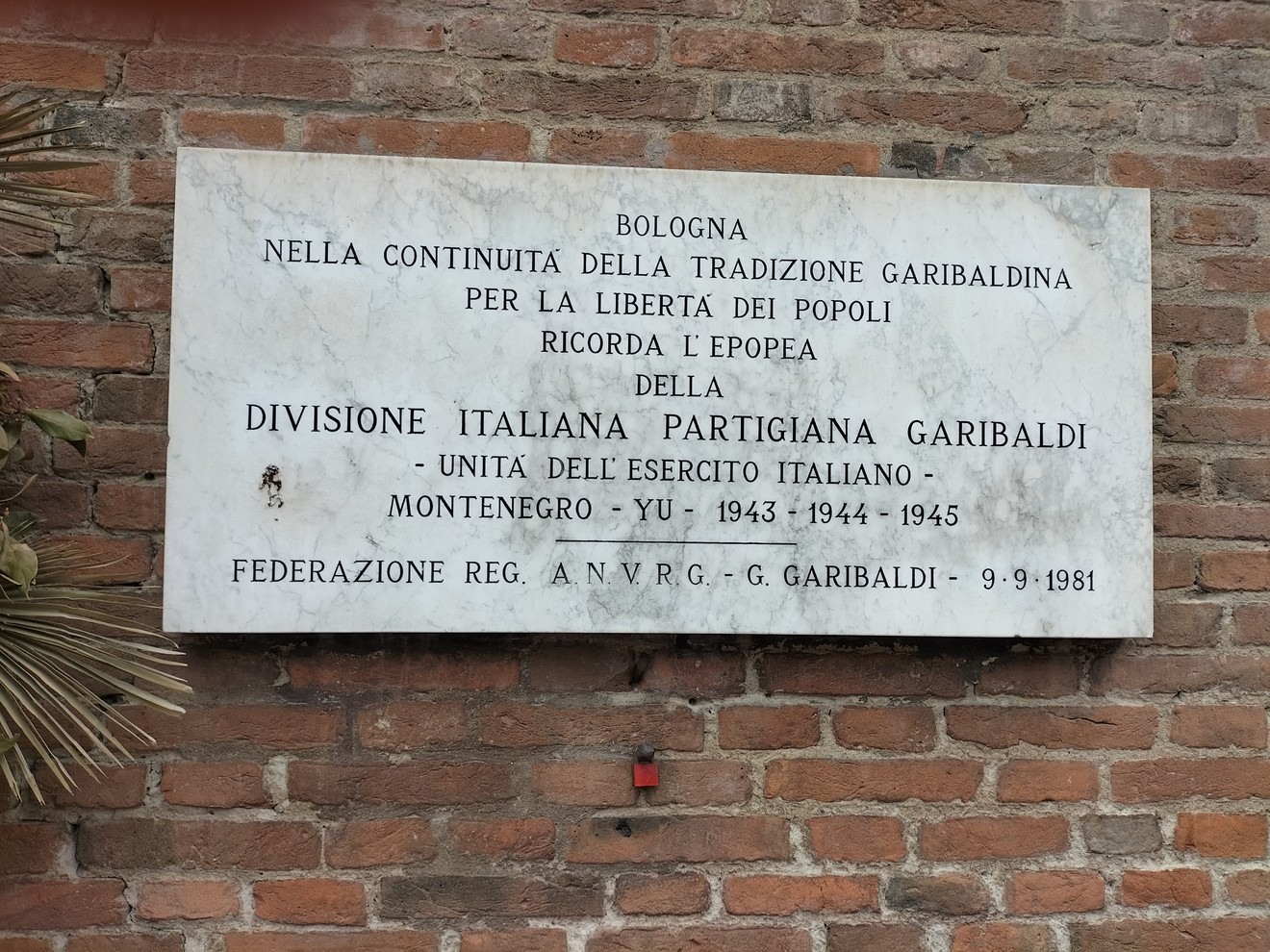 Lapide commemorativa della Divisione Garibaldi a Bologna, dedicata alla libertà dei popoli e all'unità italiana.