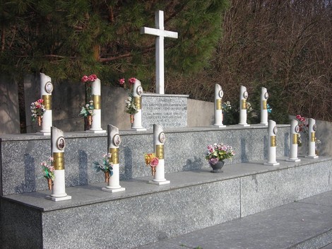 Monumento commemorativo ai martiri della Garella con colonne, fiori e una croce.