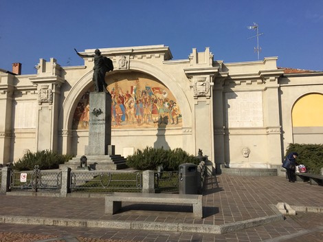 Monumento ai caduti di San Colombano al Lambro, con statue e affreschi commemorativi in un contesto storico.