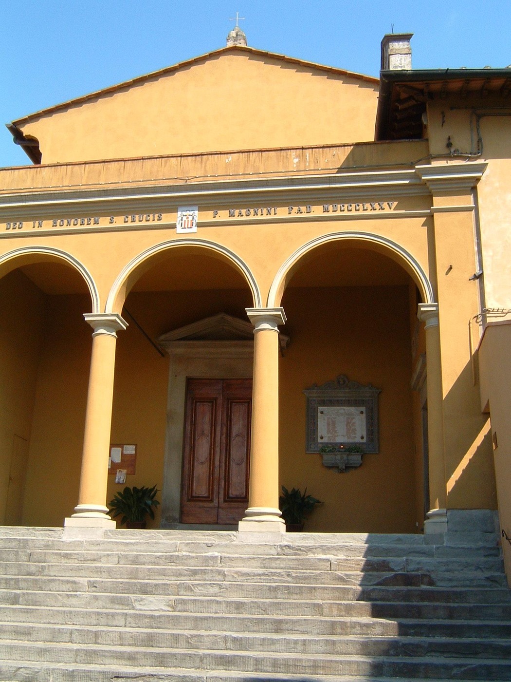 Lapide commemorativa ai caduti de La Lastra, incastonata su un edificio con colonne e gradini.