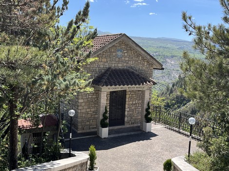 Il Sacrario della Brigata Maiella, un edificio in pietra immerso nel verde, con vista panoramica sulla vallata.