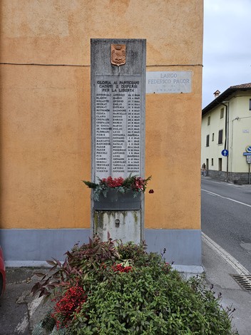 Monumento commemorativo ai Caduti per la Libertà di San Polo, con nomi incisi e decorazioni floreali.