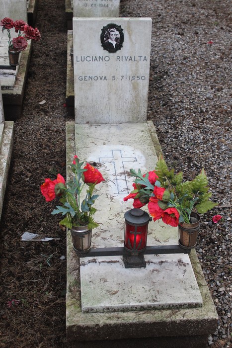 Tombe perpetue decorate con fiori rossi e candele, commemorano i caduti per la Libertà.
