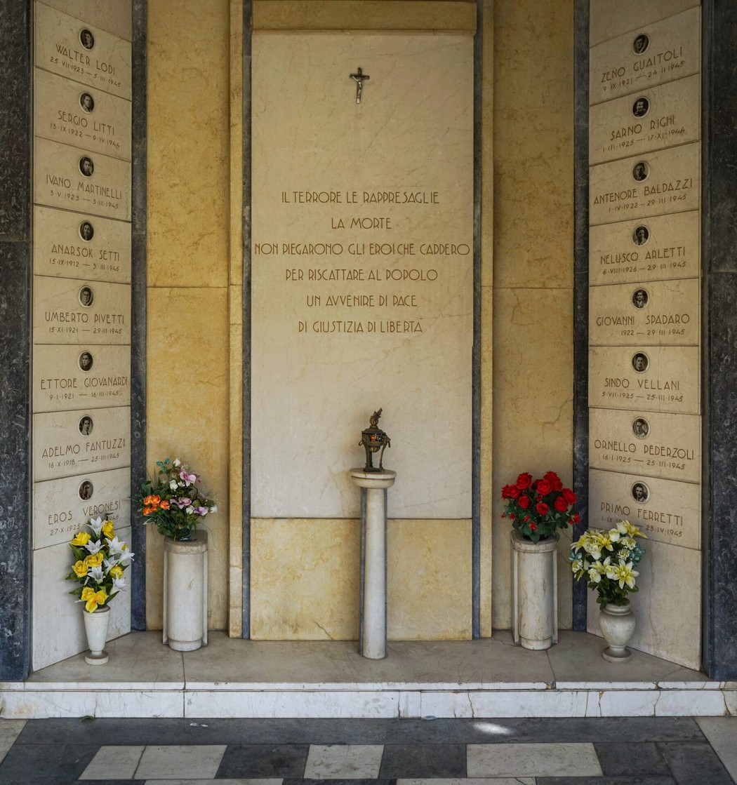 Sacrario dedicato ai caduti per la libertà a Soliera, con monumento e fiori commemorativi.