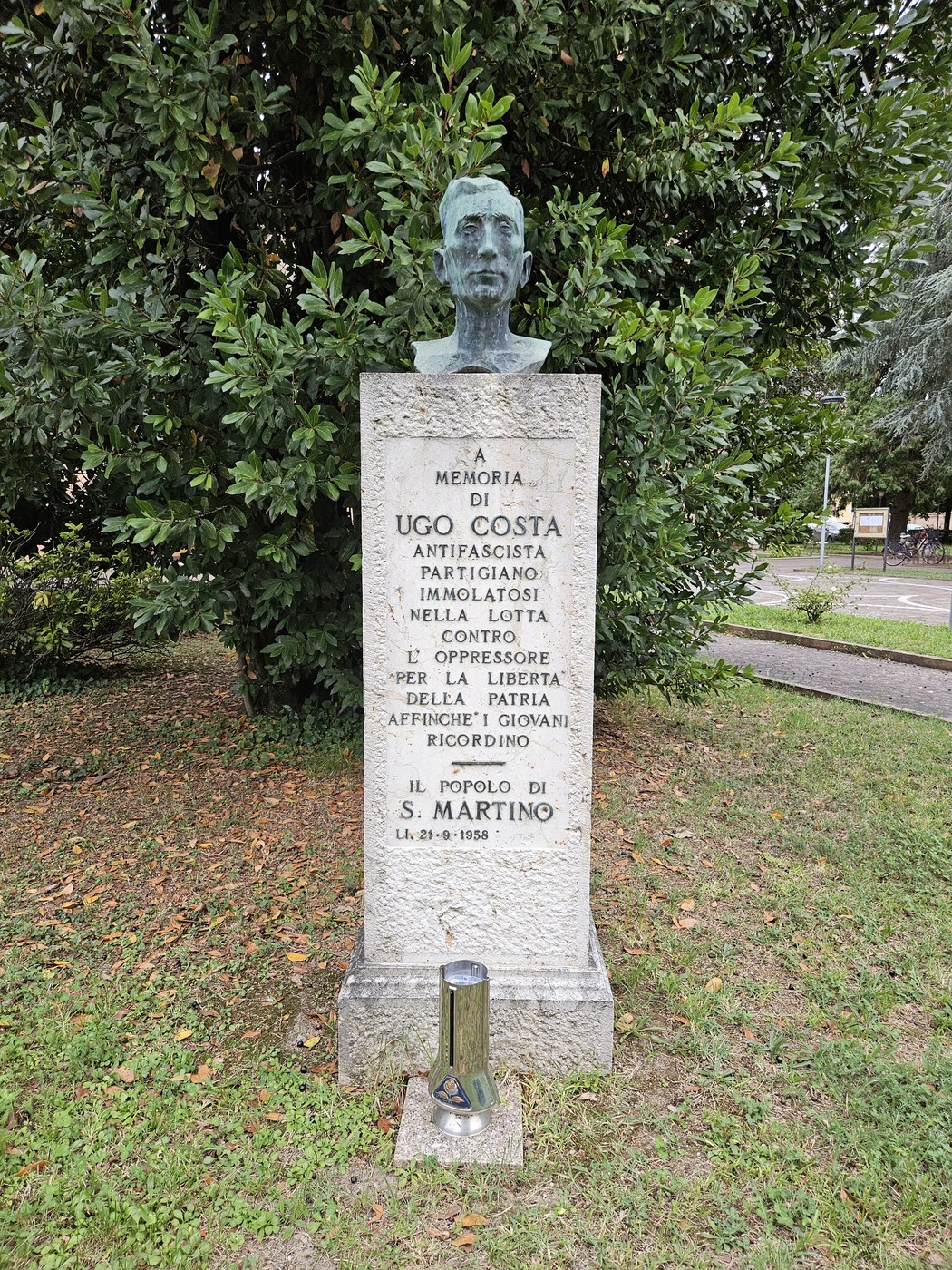Busto commemorativo di Ugo Costa, dedicato alla memoria di un partigiano, situato in un parco.