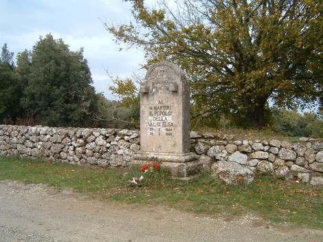 Cippo commemorativo in onore dei martiri di Montemaggio, immerso nella natura della Val di Susa.