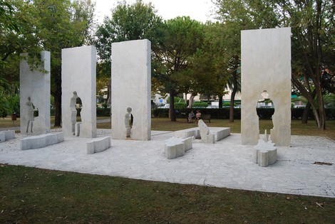 Monumento commemorativo delle vittime del fascismo, realizzato con elementi in stone e lavagna, immerso nel verde.
