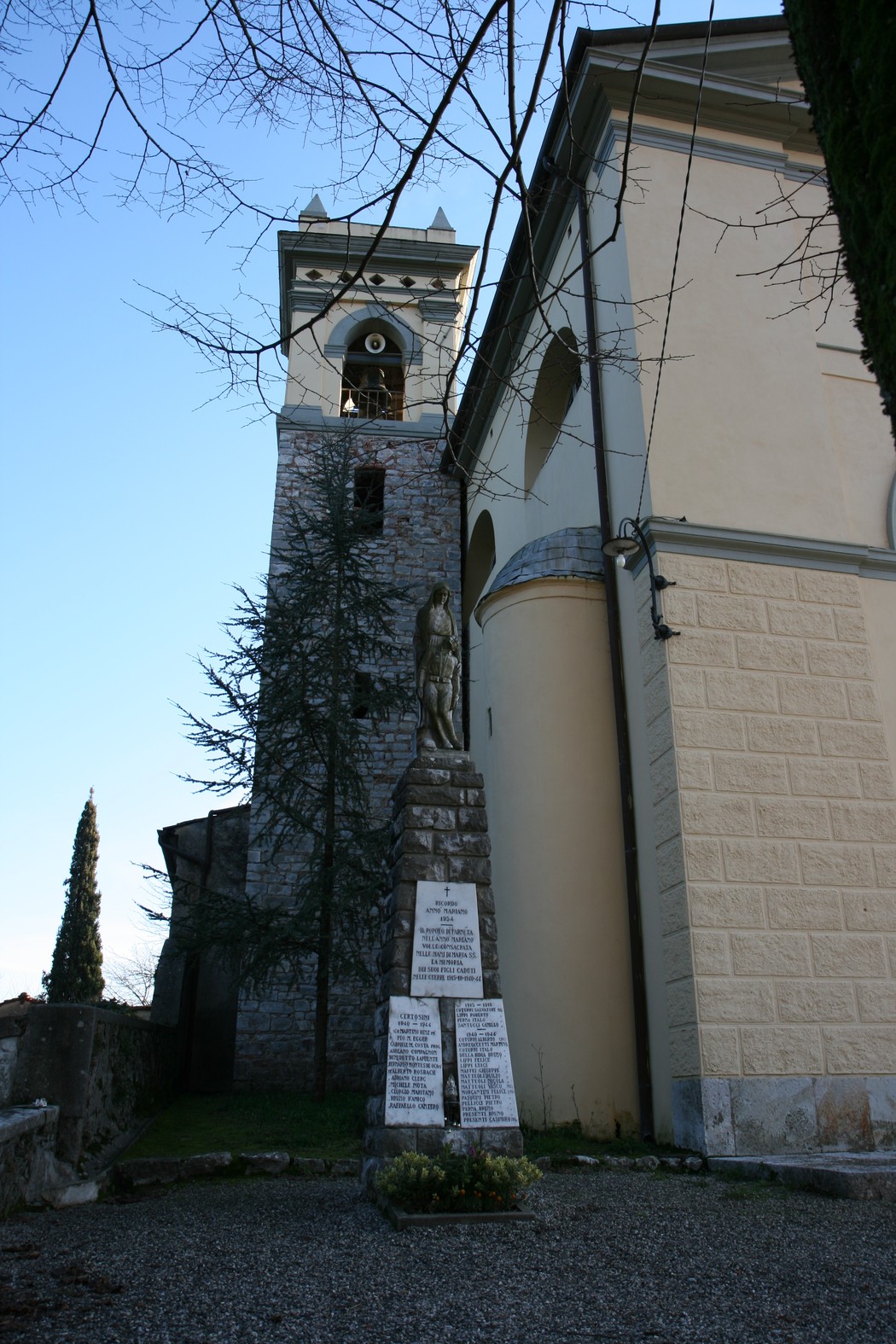 Monumento della chiesa di Farneta, con torre campanaria e statua commemorativa sullo sfondo.