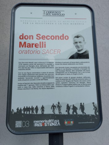 Targa commemorativa dedicata a don Secondo Marelli, con dettagli sulla sua vita e opere.