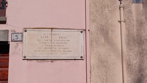 Lapide commemorativa dedicata a Lupo Gino, situata su un edificio storico.