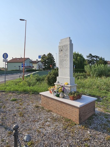 Monumento ai Martiri di Ponte Ruffio, circondato da fiori, in una zona verde e tranquilla.