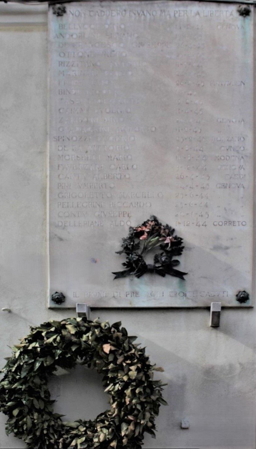 Lapide commemorativa dedicata ai caduti per la Libertà di Prè, accompagnata da una corona di fiori.