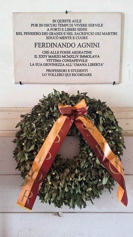 Lapide commemorativa di Ferdinando Agnini, con corona di alloro e nastro, in onore dei sacrifici per la libertà.