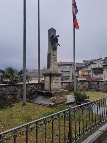 Monumento ai caduti di Chiomonte, commemorazione delle vittime, con bandiere e giardini circostanti.