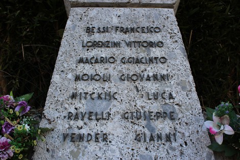 Monumento ai Tredici Martiri, con nome e omaggio ai caduti in granito e fiori decorativi.