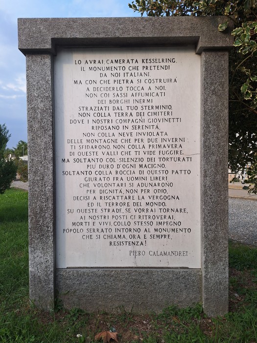Monumento in pietra con lapide iscritta, firmata Piero Calamandrei, in un'area verde all'aperto.