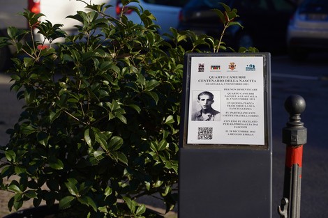 Stele commemorativa a Camurri dedicata a un centenario, con informazioni storiche e QR code.