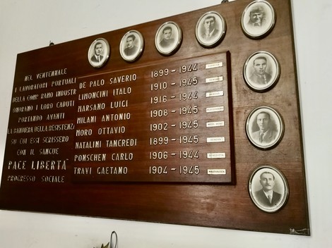 Pannello commemorativo dei caduti della Compagnia Ramo Industriale, con foto e nomi dei caduti.