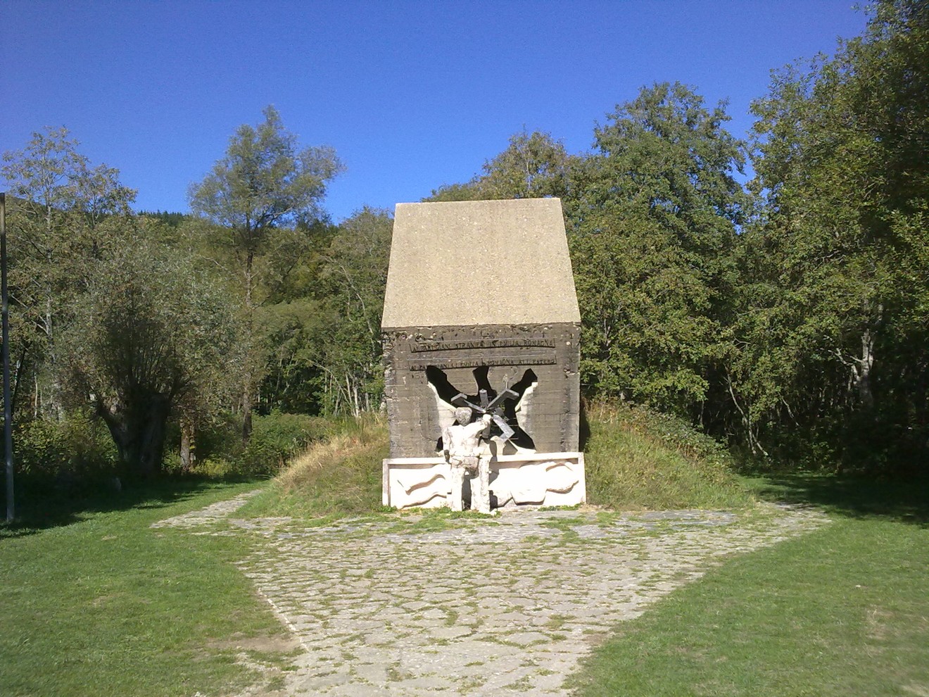 Monumento dedicato ai partigiani, simbolo di resistenza e libertà, immerso nella natura.
