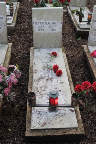 Tombe perpetue con fiori e candele in onore dei caduti per la Libertà, commemorazione di significato storico.