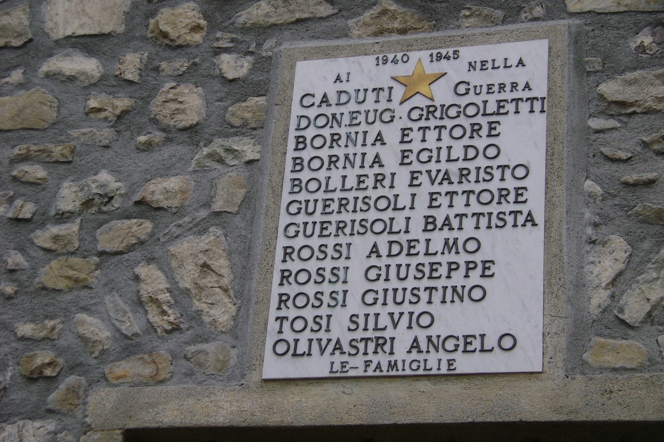Lapide commemorativa dedicata ai caduti di Adelano, con nomi e date di guerra 1940-1945.