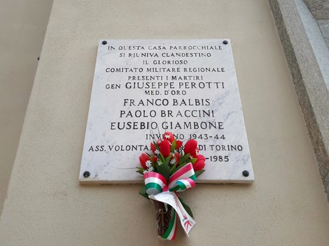 Lapide commemorativa dedicata ai martiri del Comitato Militare Regionale Piemontese, con omaggio floreale.