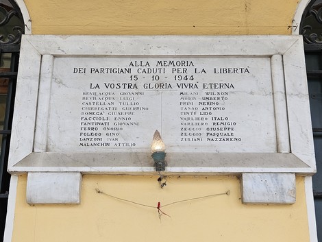 Lapide commemorativa dedicata ai partigiani caduti per la libertà, con nomi incisi in memoria.