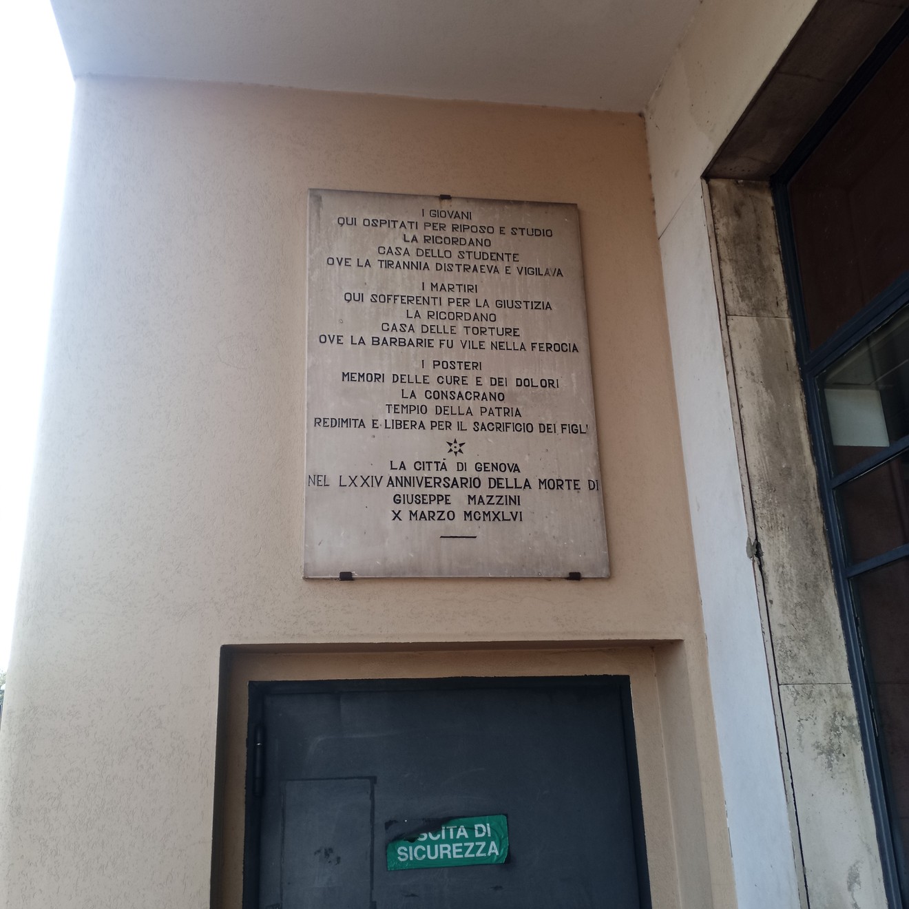 Lapide commemorativa dedicata agli studenti di "Casa dello Studente" con iscrizioni in memoria di eventi storici.