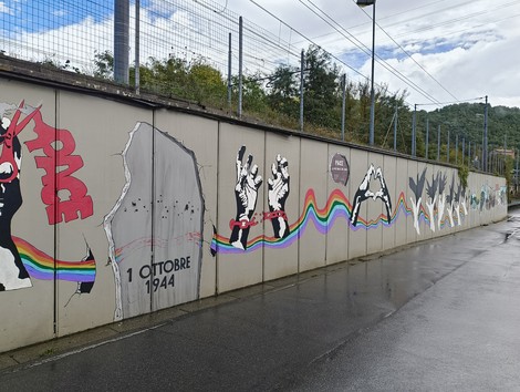 Murale di Pioppe con graffiti colorati che ricordano eventi storici e simboli di pace.