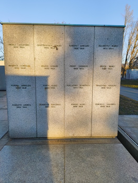 Monumento commemorativo con nomi incisi su lastre di pietra, dedicato ai caduti in guerra.