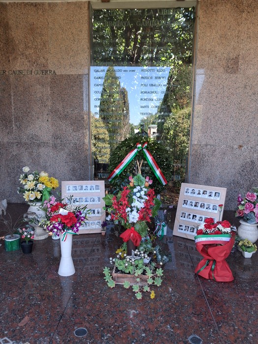Sacrario dei Partigiani decorato con fiori e tributi in memoria dei caduti, situato in un ambiente tranquillo e commemorativo.