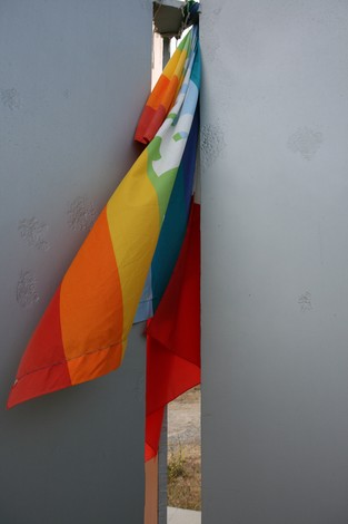Monumento a Chiesa con bandiere colorate visibili tra le pareti, simbolo di inclusione e diversità.
