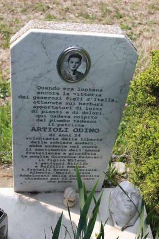 Cippo commemorativo dedicato ad Artioli e Bruni, con epigrafe in onore dei caduti, immerso nel verde.