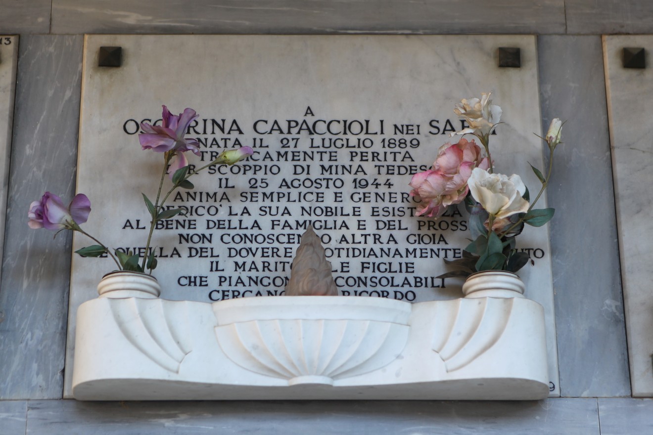 Sepolcro di Capaccioli, in onore di Osirina, con fiori e una placca commemorativa.