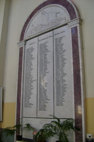 Memoriale dedicato ai caduti, con un elenco di nomi e un'imponente struttura architettonica.