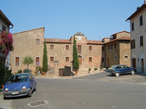 Il Sacrario dell'eccidio di San Pancrazio, un antico edificio in pietra con un grande orologio e automotive nelle vicinanze.