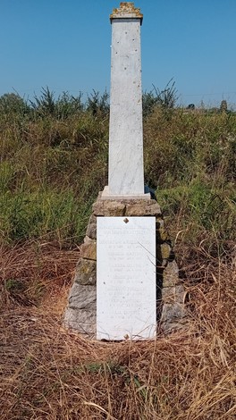 Cippo commemorativo dedicato ai sette partigiani di Breda Cisoni, immerso nella natura circostante.
