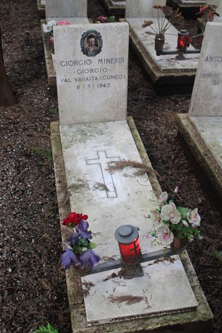 Tombe di caduti per la Libertà, con croci e fiori, in un ambiente commemorativo e silenzioso.