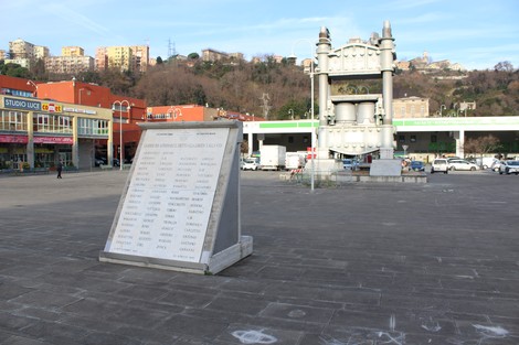 Monumento ai caduti per la Libertà di Campi, situato in una piazza con edifici e colline sullo sfondo.