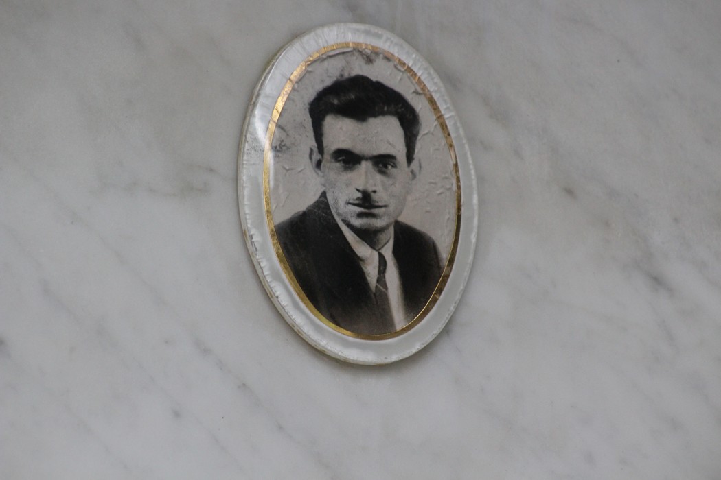 Ritratto di un uomo incastonato in una cornice su un monumento, dedicato ai caduti per la Liberazione.