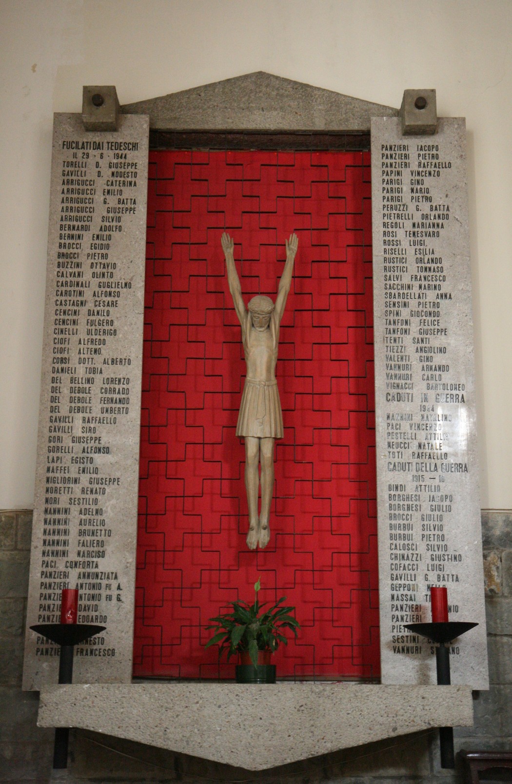 Sacrario nella chiesa di San Pancrazio, con statue e nomi commemorativi su una parete rossa.