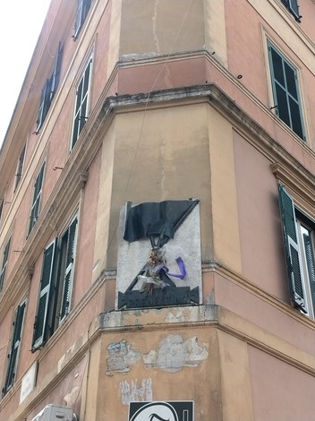 Lapide commemorativa per i caduti dell'Atac durante la Guerra di Liberazione, posizionata su un edificio angolare.