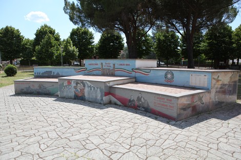 Murali colorati e commemorativi nel parco della Liberazione, immersi nel verde e sotto un cielo sereno.