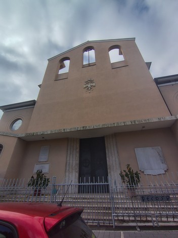 Lapidi commemorative ai caduti di guerra nel quartiere Tuscolano, con edifici storici sullo sfondo.