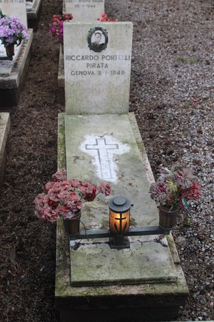 Tombe con fiori e candele, dedicate ai caduti per la Libertà, in un cimitero.