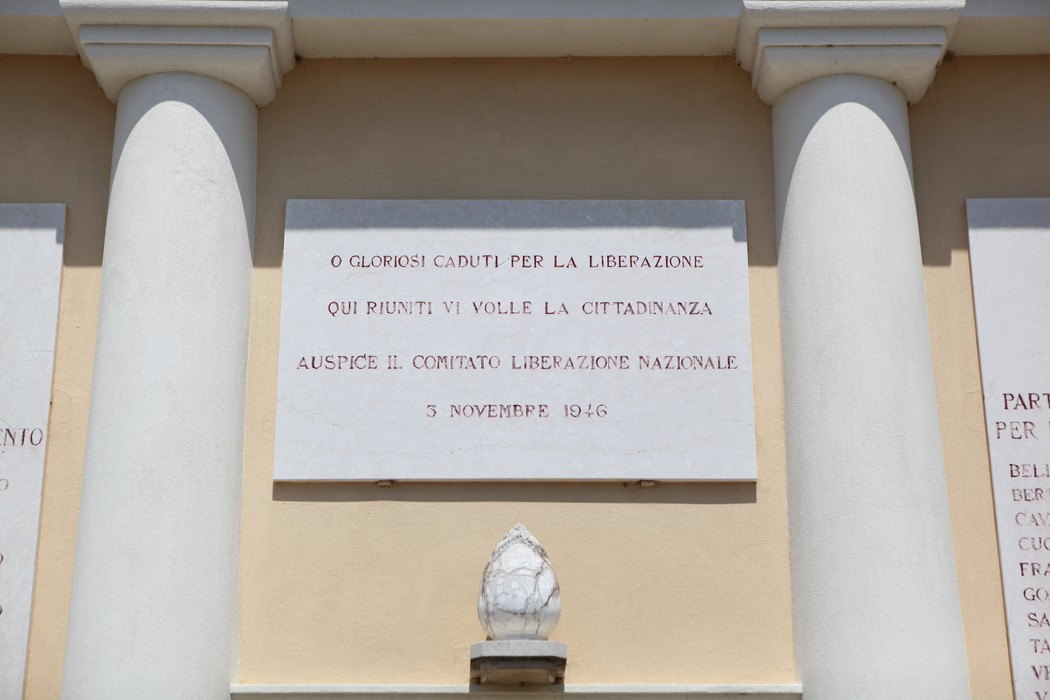 Sacrario dei Caduti per la Liberazione, con iscrizioni commemorative su una parete e colonne bianche.