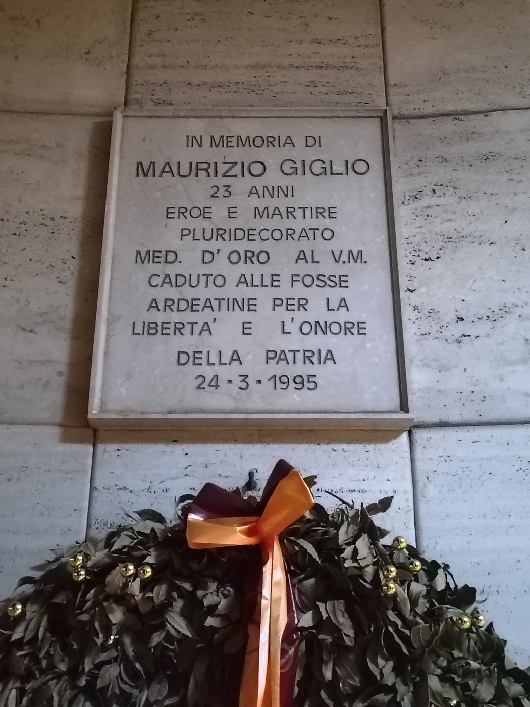 Lapide commemorativa dedicata a Maurizio Giglio, eroe e martire, con una corona di alloro.