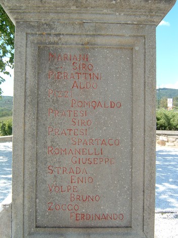 Area monumentale di Sant'Andrea con epigrafi storiche incise su una stele in pietra. Atmosfera di ricordo e contemplazione.