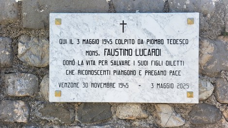Lapide commemorativa di mons. Faustino Lucardi, ucciso il 3 maggio 1945, situata in un contesto di pietra.