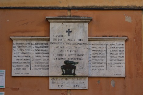 Lapide commemorativa dedicata ai caduti per la libertà, con nomi e date incisi su marmo.